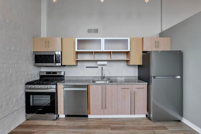60 E Spring St Unit 327, Columbus, OH 43215 - kitchen featuring stainless steel appliances, a sink, light brown cabinets, and open shelves