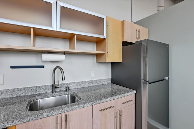 60 E Spring St Unit 327, Columbus, OH 43215 - kitchen featuring light brown cabinetry, open shelves, a sink, freestanding refrigerator, and stone countertops