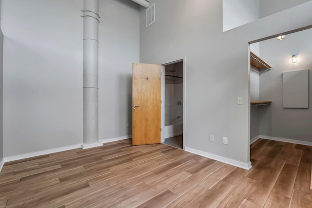 60 E Spring St Unit 327, Columbus, OH 43215 - unfurnished bedroom with wood finished floors, baseboards, a spacious closet, and a closet