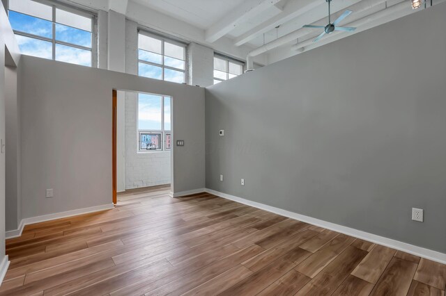 60 E Spring St Unit 327, Columbus, OH 43215 - empty room with beamed ceiling, a ceiling fan, wood finished floors, a towering ceiling, and baseboards