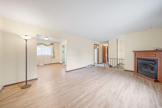 299 Sherwood Downs S, Newark, OH 43055 - unfurnished living room featuring light wood-style floors, baseboards, and a glass covered fireplace