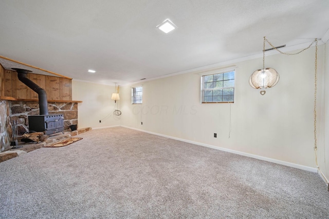 299 Sherwood Downs S, Newark, OH 43055 - unfurnished living room featuring a wood stove, carpet flooring, baseboards, and crown molding