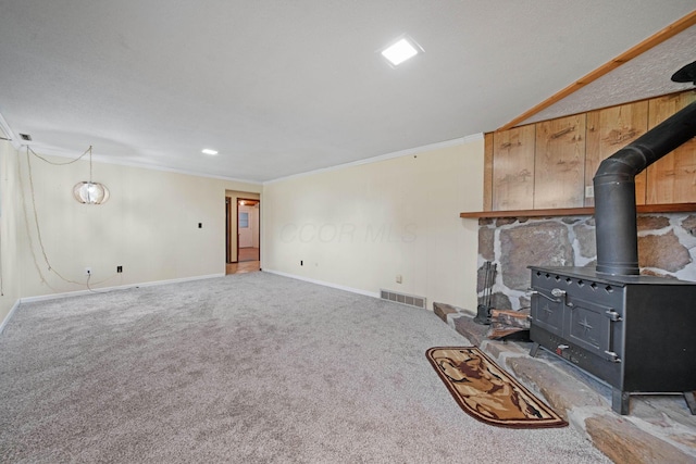 299 Sherwood Downs S, Newark, OH 43055 - unfurnished living room featuring a wood stove, baseboards, ornamental molding, and carpet floors