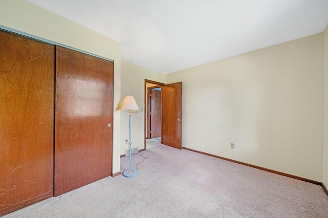 299 Sherwood Downs S, Newark, OH 43055 - unfurnished bedroom featuring light carpet, a closet, and baseboards