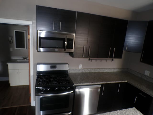 905-907 Beech St, Columbus, OH 43206 - kitchen featuring stainless steel appliances, a sink, dark cabinetry, and dark wood finished floors