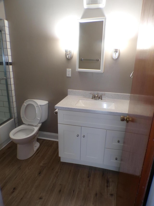 905-907 Beech St, Columbus, OH 43206 - bathroom featuring vanity, wood finished floors, toilet, and bath / shower combo with glass door