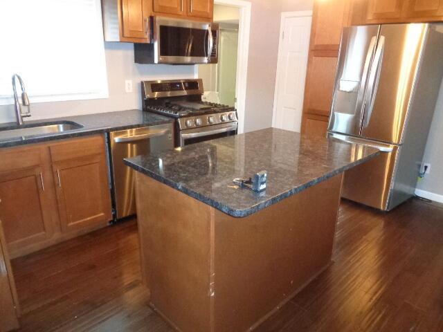 905-907 Beech St, Columbus, OH 43206 - kitchen with appliances with stainless steel finishes, a sink, dark wood-style flooring, and a center island