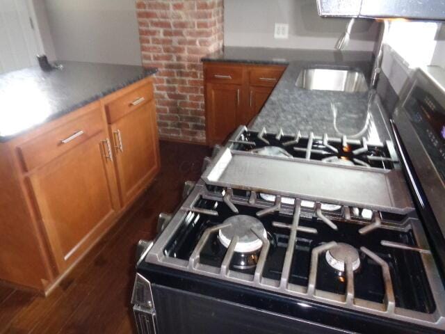 905-907 Beech St, Columbus, OH 43206 - kitchen with brown cabinets, a sink, range with gas cooktop, dark wood-style flooring, and dark countertops