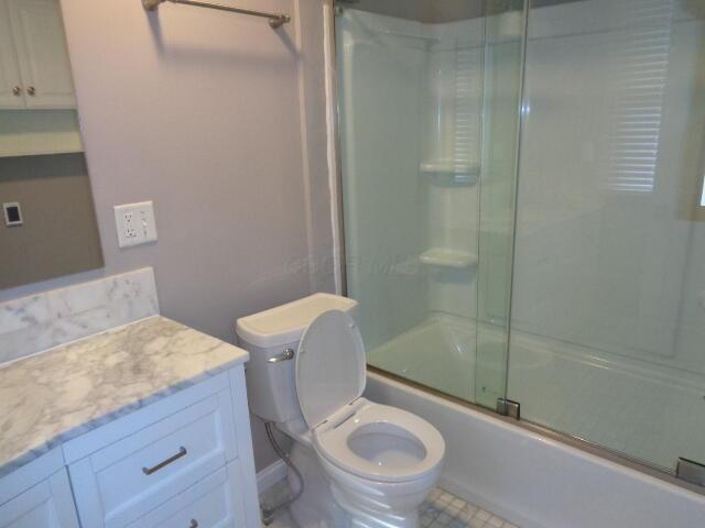 905-907 Beech St, Columbus, OH 43206 - full bathroom featuring vanity, toilet, and bath / shower combo with glass door