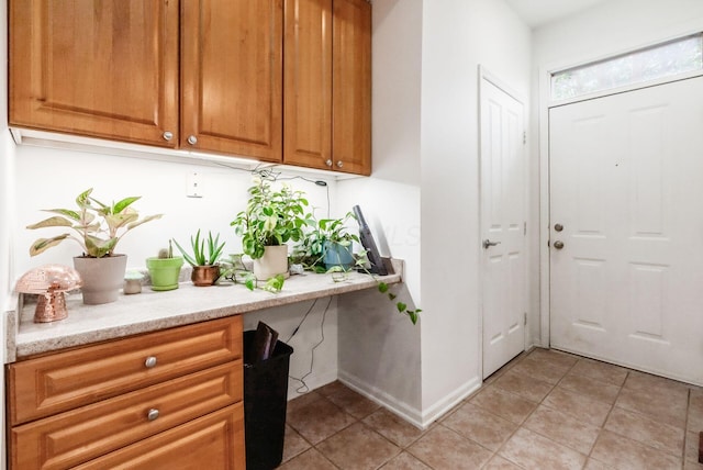 797 S Front St, Columbus, OH 43206 - kitchen with light tile patterned floors, brown cabinetry, and light stone countertops