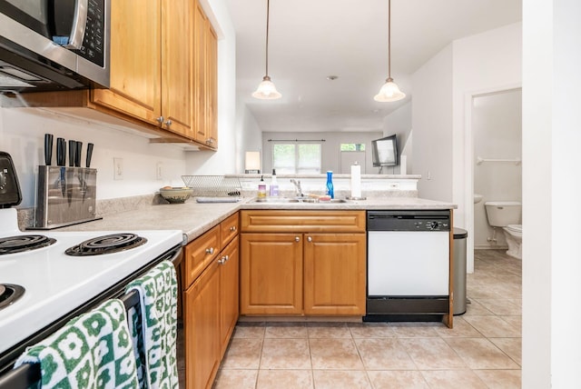 797 S Front St, Columbus, OH 43206 - kitchen featuring white appliances, a sink, a peninsula, light countertops, and light tile patterned floors