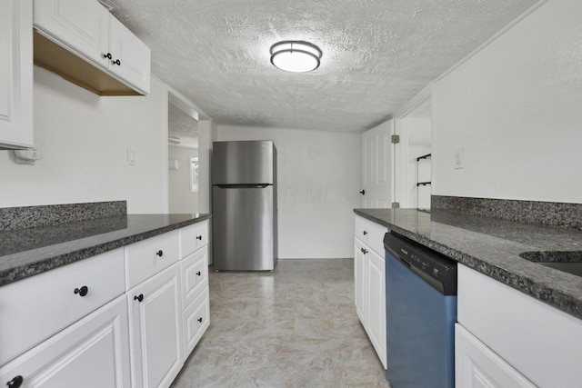 663 E Mound St, Circleville, OH 43113 - kitchen featuring freestanding refrigerator, dishwashing machine, a textured ceiling, white cabinets, and dark stone countertops