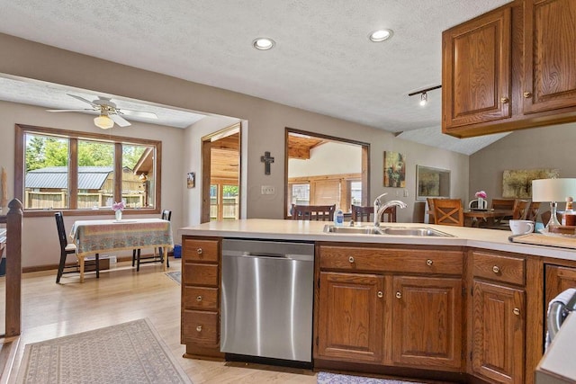 6799 Thrasher Ct, Orient, OH 43146 - kitchen featuring stainless steel dishwasher, a sink, a textured ceiling, brown cabinetry, and light wood finished floors