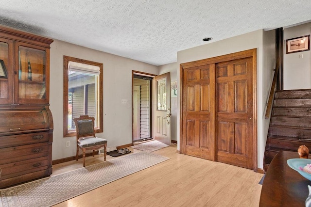 6799 Thrasher Ct, Orient, OH 43146 - foyer featuring light wood finished floors, a textured ceiling, stairs, and baseboards