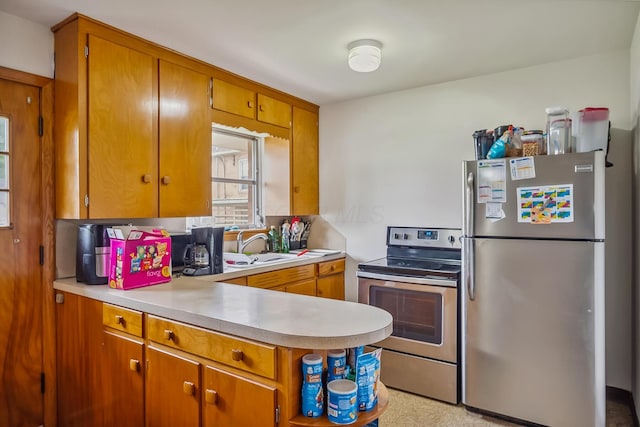 320 N 3rd St, Coshocton, OH 43812 - kitchen featuring appliances with stainless steel finishes, light countertops, brown cabinetry, a peninsula, and a sink