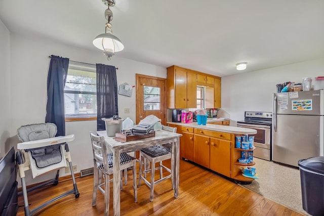 320 N 3rd St, Coshocton, OH 43812 - kitchen with appliances with stainless steel finishes, light countertops, light wood-style floors, and a peninsula