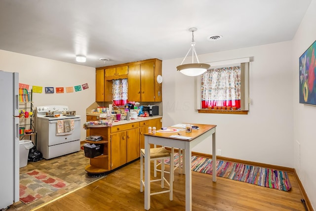 320 N 3rd St, Coshocton, OH 43812 - kitchen with white appliances, wood finished floors, open shelves, light countertops, and brown cabinetry