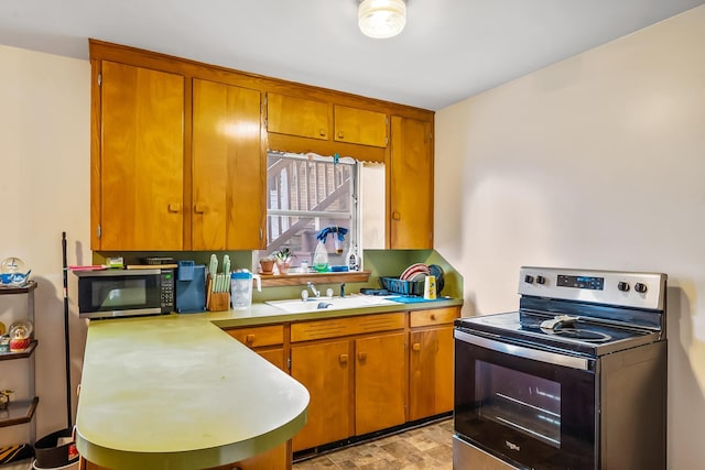 320 N 3rd St, Coshocton, OH 43812 - kitchen featuring appliances with stainless steel finishes, light countertops, brown cabinets, and a sink