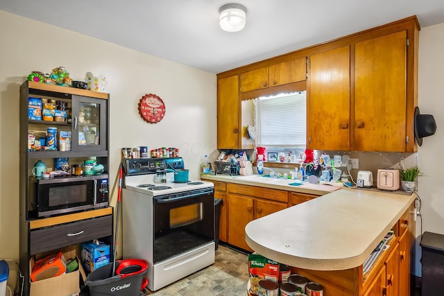 320 N 3rd St, Coshocton, OH 43812 - kitchen with white range with electric cooktop, brown cabinetry, and light countertops