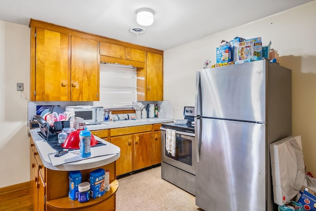 320 N 3rd St, Coshocton, OH 43812 - kitchen with stainless steel appliances, brown cabinets, a sink, light countertops, and open shelves