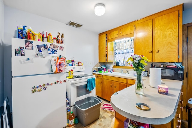 320 N 3rd St, Coshocton, OH 43812 - kitchen featuring white appliances, light countertops, brown cabinetry, a sink, and a peninsula