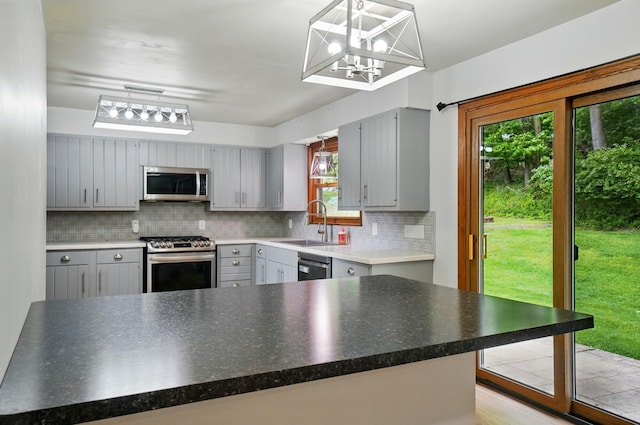 1244 N Broad St, Lancaster, OH 43130 - kitchen featuring stainless steel appliances, gray cabinets, a sink, tasteful backsplash, and a chandelier