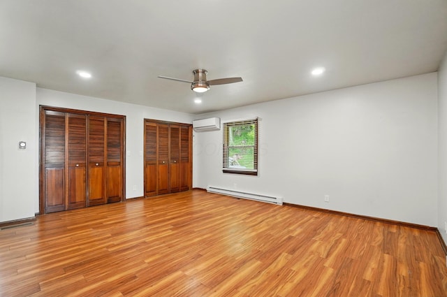 1244 N Broad St, Lancaster, OH 43130 - unfurnished bedroom with a baseboard heating unit, an AC wall unit, light wood finished floors, two closets, and recessed lighting