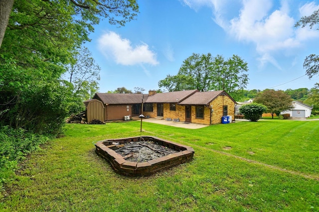 1244 N Broad St, Lancaster, OH 43130 - back of house with an outdoor fire pit, a patio, a yard, a chimney, and brick siding