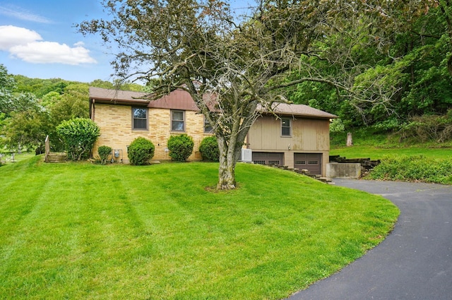 1244 N Broad St, Lancaster, OH 43130 - view of front facade with asphalt driveway, a front lawn, an attached garage, and brick siding