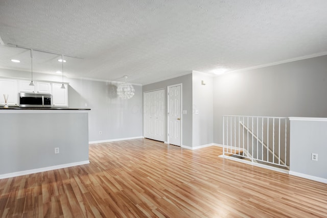 5373 Cypress Chase, Columbus, OH 43228 - unfurnished living room with a textured ceiling, a chandelier, light wood finished floors, recessed lighting, and crown molding