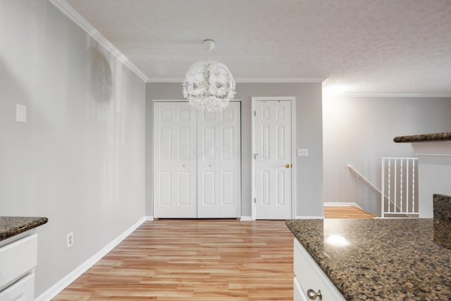 5373 Cypress Chase, Columbus, OH 43228 - unfurnished dining area with light wood-style floors, a chandelier, crown molding, baseboards, and a textured ceiling