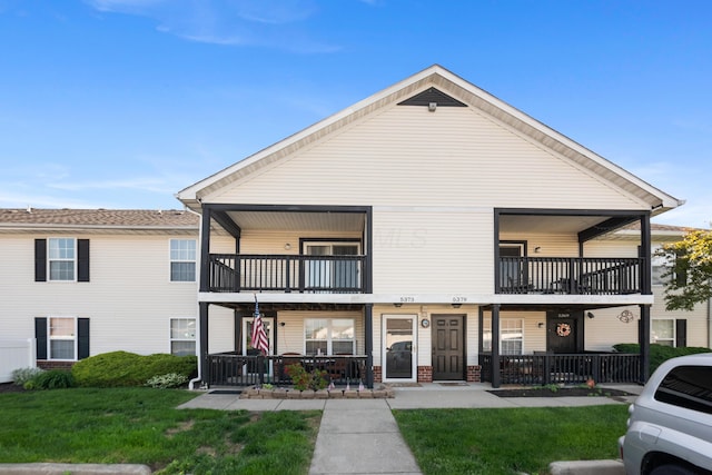 5373 Cypress Chase, Columbus, OH 43228 - view of front of property featuring a balcony, covered porch, a front lawn, and brick siding