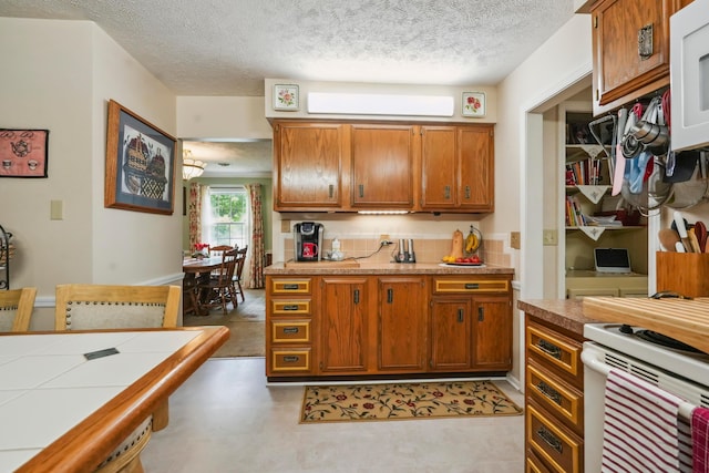 1235 Canteberry Ln, Mansfield, OH 44906 - kitchen with brown cabinetry, a textured ceiling, white microwave, and a wall unit AC