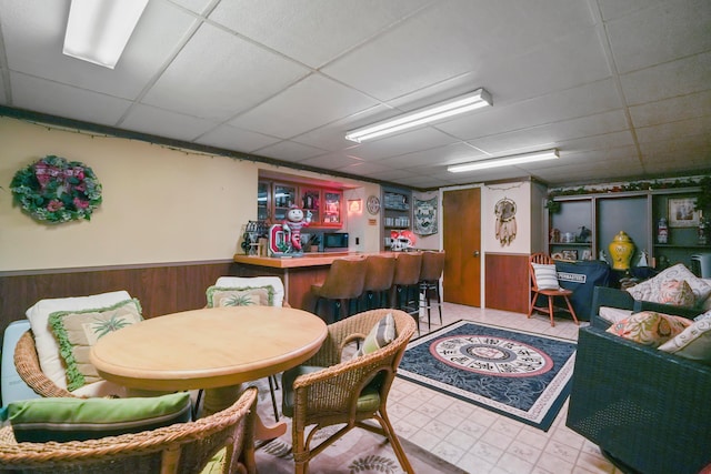 1235 Canteberry Ln, Mansfield, OH 44906 - indoor dry bar featuring a drop ceiling, wainscoting, wood walls, tile patterned floors, and stainless steel microwave