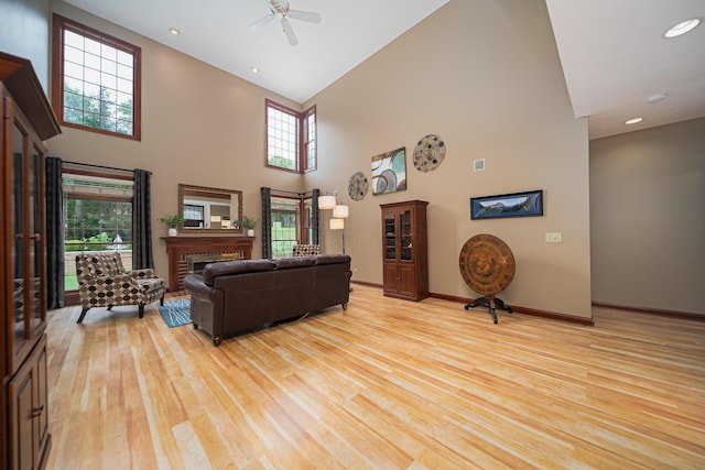 390 Engelwood Ct, Powell, OH 43065 - living room with high vaulted ceiling, light wood-style flooring, ceiling fan, healthy amount of natural light, and a fireplace