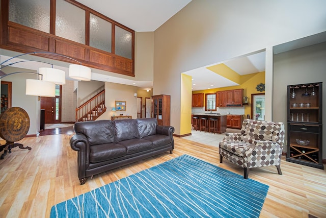 390 Engelwood Ct, Powell, OH 43065 - living area with a towering ceiling, light wood-style flooring, and stairs
