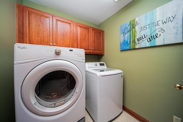 390 Engelwood Ct, Powell, OH 43065 - washroom featuring cabinet space, washer and clothes dryer, light tile patterned floors, and a textured ceiling