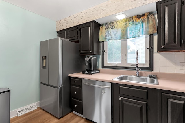 1200 Chanteloup Dr, Marion, OH 43302 - kitchen featuring stainless steel appliances, a sink, light countertops, light wood-style floors, and decorative backsplash