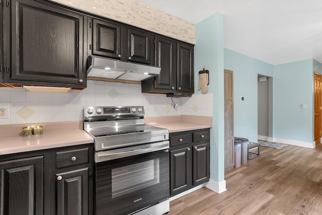 1200 Chanteloup Dr, Marion, OH 43302 - kitchen featuring under cabinet range hood, electric stove, dark cabinetry, light countertops, and light wood finished floors