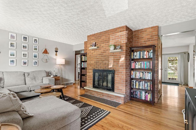 2690 Kingston Ave, Grove City, OH 43123 - living area with wood finished floors, a brick fireplace, and a textured ceiling