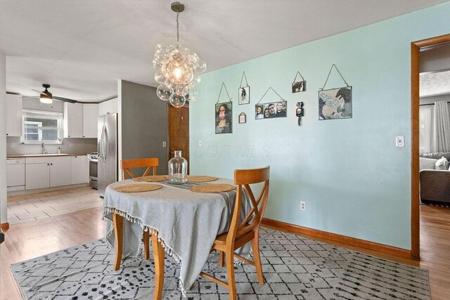 2690 Kingston Ave, Grove City, OH 43123 - dining area featuring light wood-style floors, a chandelier, ceiling fan, and baseboards