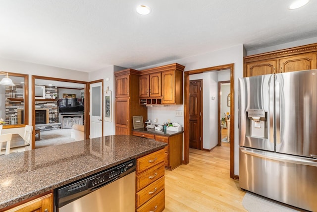 1861 Ginder Rd NW, Lancaster, OH 43130 - kitchen with stainless steel appliances, dark stone counters, light wood-style floors, brown cabinets, and recessed lighting
