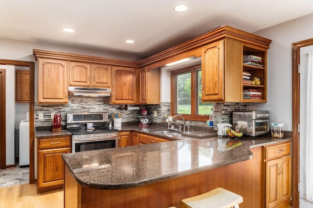 1861 Ginder Rd NW, Lancaster, OH 43130 - kitchen featuring a sink, stainless steel electric stove, under cabinet range hood, dark stone counters, and a peninsula