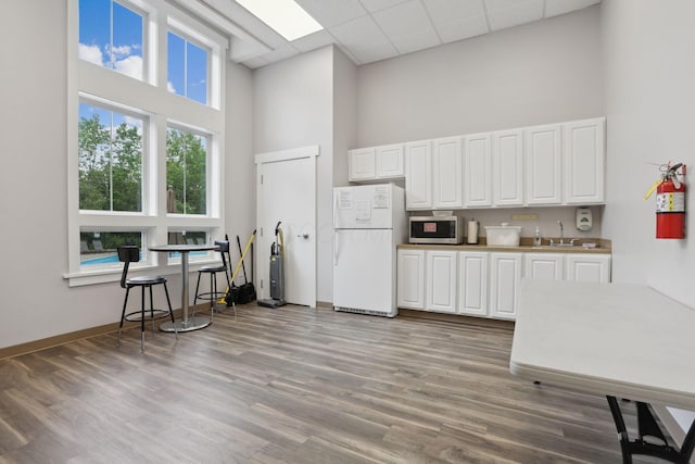 2079 Tournament Way, Grove City, OH 43123 - kitchen featuring freestanding refrigerator, a high ceiling, stainless steel microwave, a sink, and white cabinetry