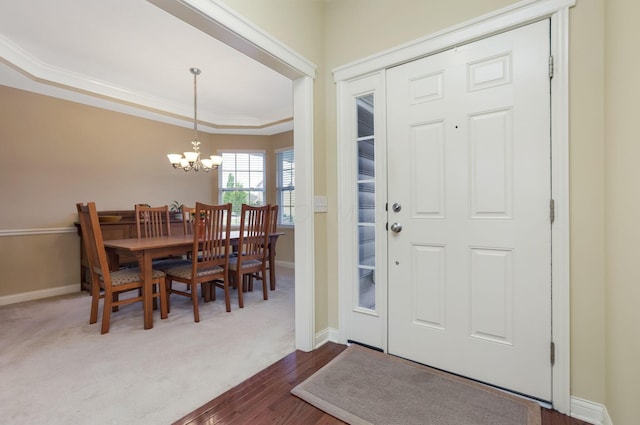 2079 Tournament Way, Grove City, OH 43123 - foyer with a chandelier, baseboards, dark wood-style flooring, crown molding, and a tray ceiling