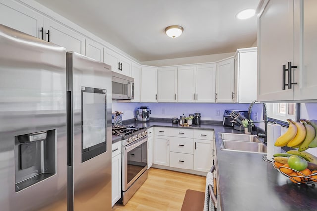 600 Kappler Rd, Heath, OH 43056 - kitchen with appliances with stainless steel finishes, dark countertops, white cabinetry, a sink, and light wood-style flooring