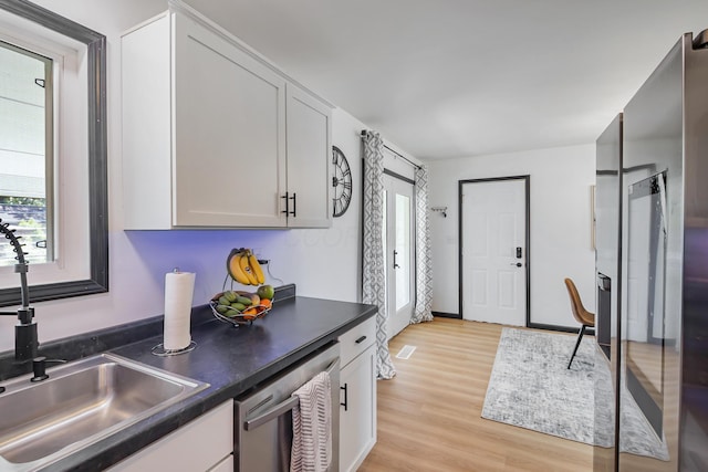 600 Kappler Rd, Heath, OH 43056 - kitchen with stainless steel dishwasher, a sink, light wood-style flooring, dark countertops, and white cabinetry