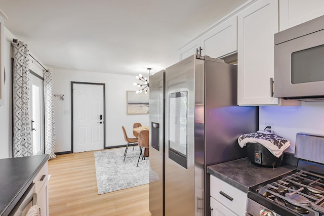 600 Kappler Rd, Heath, OH 43056 - kitchen with appliances with stainless steel finishes, a chandelier, light wood finished floors, dark countertops, and white cabinets