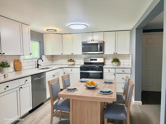 13212 Maple Rd NE, Thornville, OH 43076 - kitchen featuring stainless steel appliances, light wood-style floors, a sink, and decorative backsplash