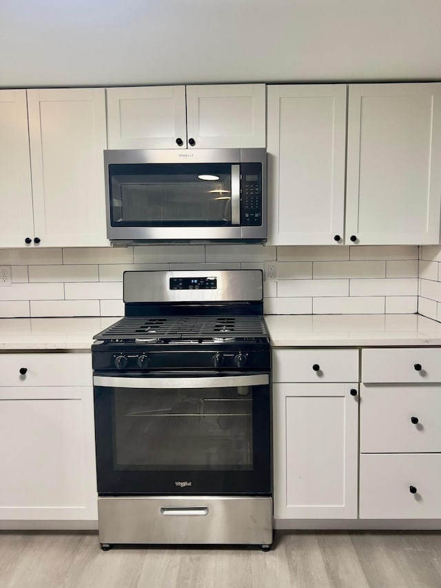 13212 Maple Rd NE, Thornville, OH 43076 - kitchen with stainless steel appliances, light wood finished floors, light countertops, and backsplash